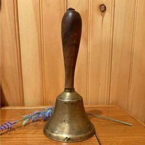 Antique brass school bell with a wooden handle vintage